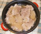 Fokhagymás hús - A hússzeletek a serpenyőben, szafttal leöntve, sütésre készen.