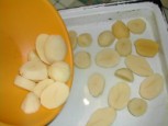 Sütőben sült krumpli - A tálból borítsd a forró olajos tepsibe a krumplit!