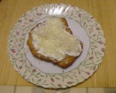 Lángos - A kész tejfölös-sajtos lángos tányéron.